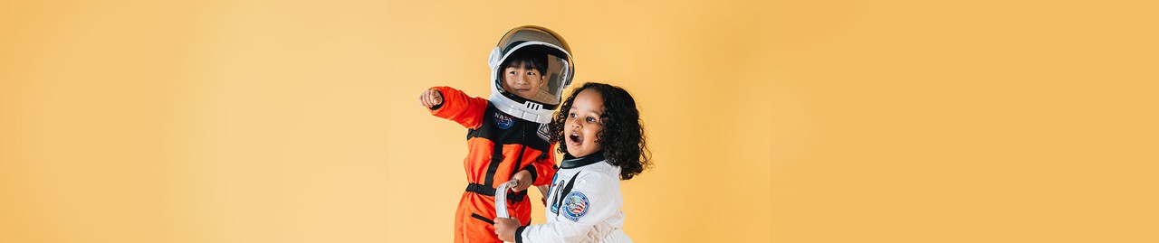 menino e menina com uma fantasia de astronauta branca e laranja