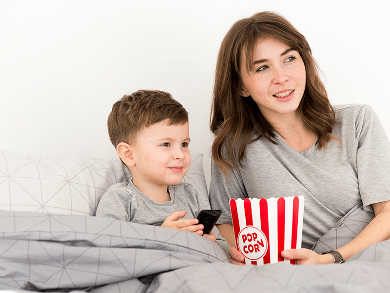 mãe e filho assistem filme juntos