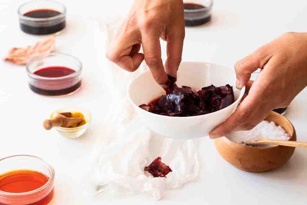 pessoa fazendo tinta natural com vegetal e fruta 