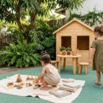 Dupla de meninas brincando em jardim com brinquedos de madeira