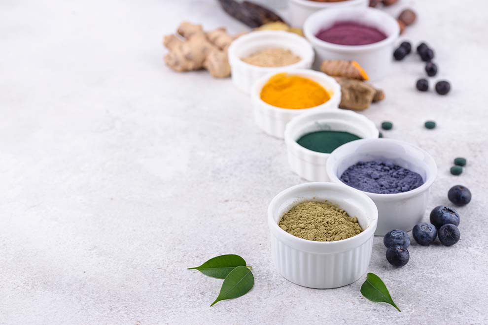 tinta de frutas e legumes dentro de uma pequena tigela com as frutas e legumes ao lado em cima de uma mesa branca 