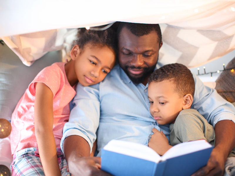pai lendo livros para os filhos