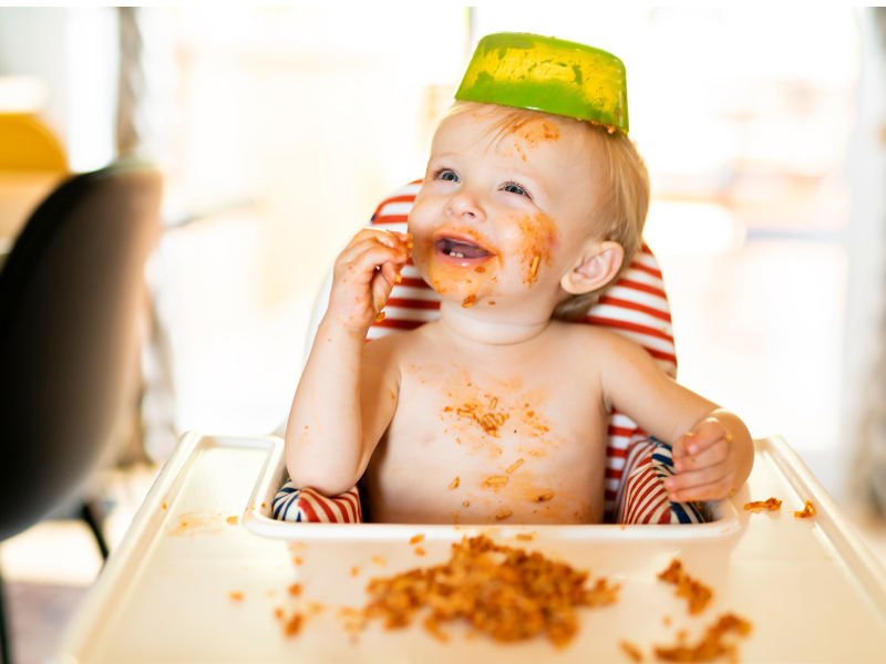 bebê comendo macarrão sozinho todo melecado de molho