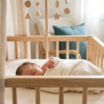 Bebê dormindo em berço de madeira com móveis modernos.