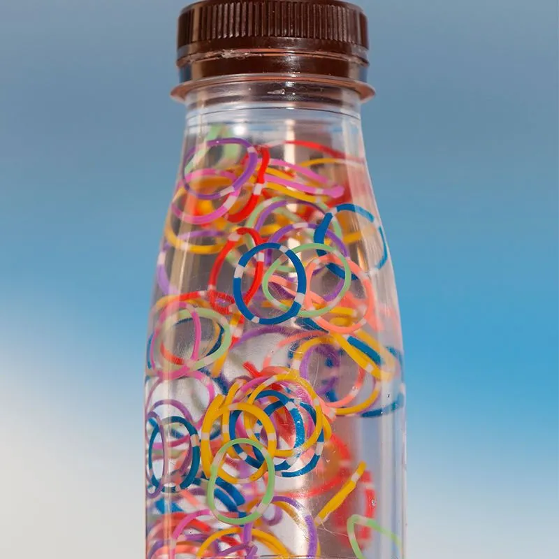 Brinquedo feito de garrafa cheia de água e argolinhas coloridas