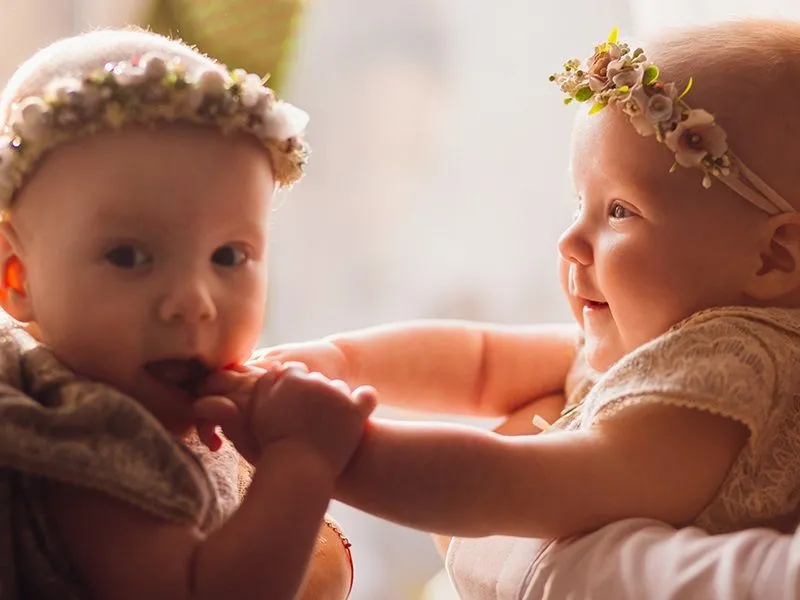 bebês gêmeos com coroa de flores