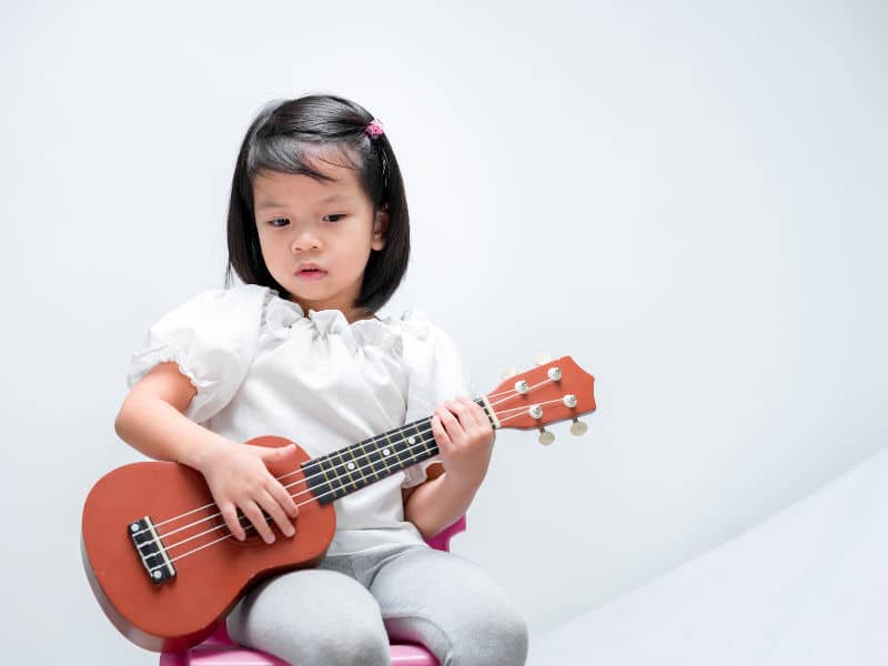 menininha tocando ukulele