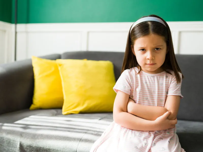 menina de três anos com uma expressão de brava