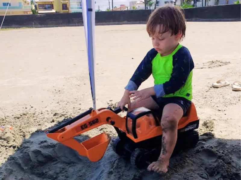 menino de 3 anos brincando na areia 