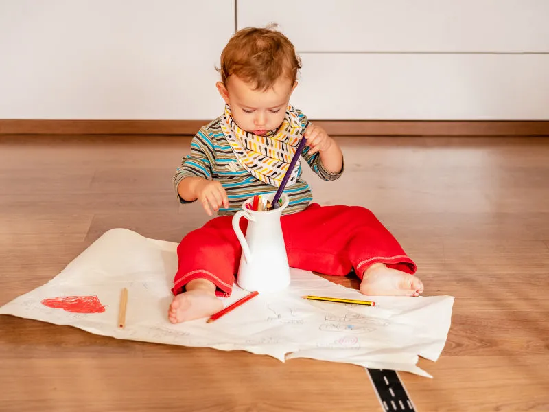 bebê de um ano brincando no chão