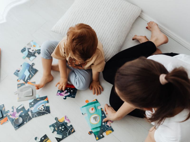 mãe e filho brincando de quebra cabeças