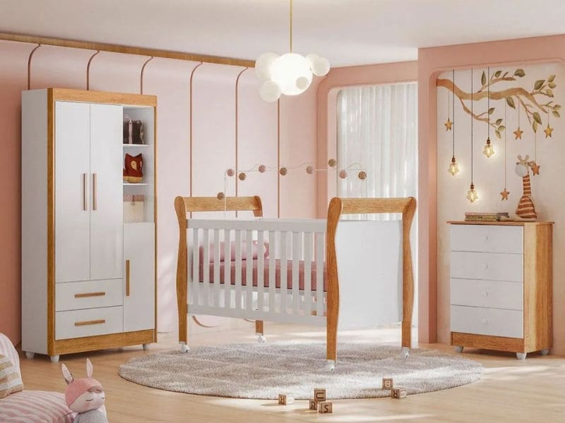 Um quarto de bebê aconchegante com berço, cômoda e guarda-roupa em tons de madeira e branco. Um mural de uma árvore com decorações de estrelas penduradas adorna a parede e um brinquedo de pelúcia está no chão. Uma luminária em forma de nuvem está pendurada no teto.