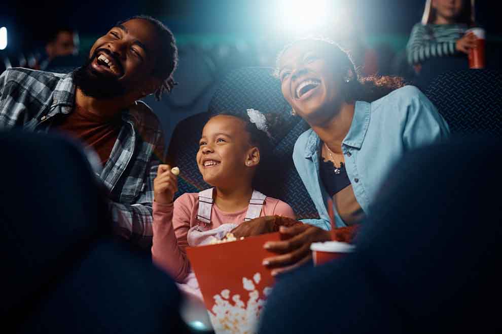 Família se divertindo no cinema com pipoca