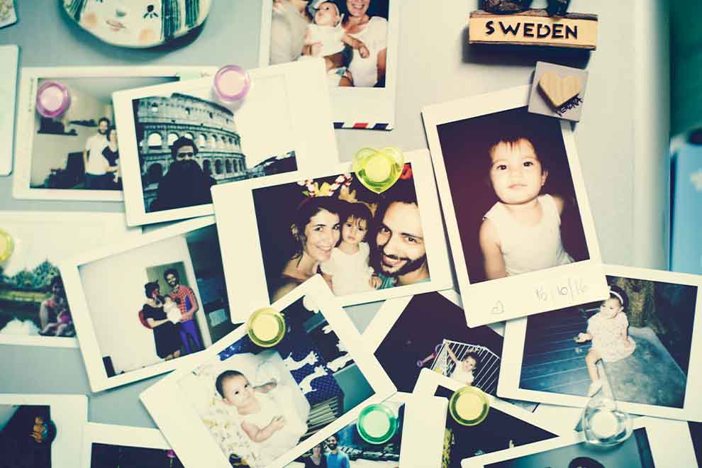 Diversas fotos em uma geladeira, incluindo retratos familiares.