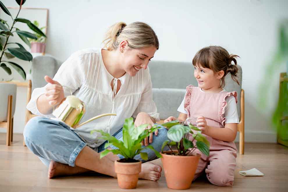 Mãe e filha cuidando de plantas em casa