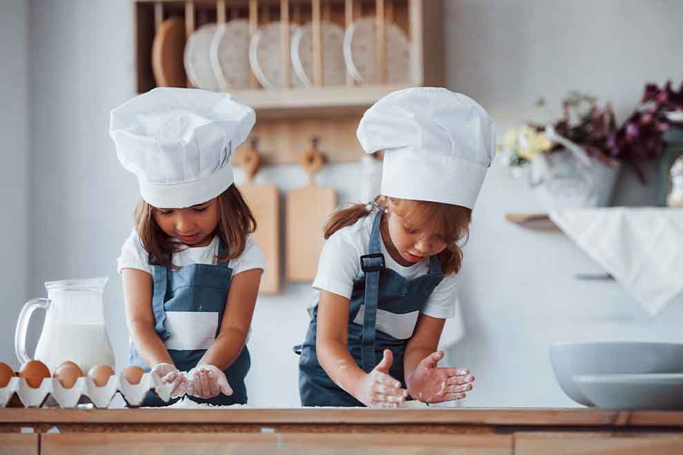 Duas meninas cozinheiros preparando uma receita