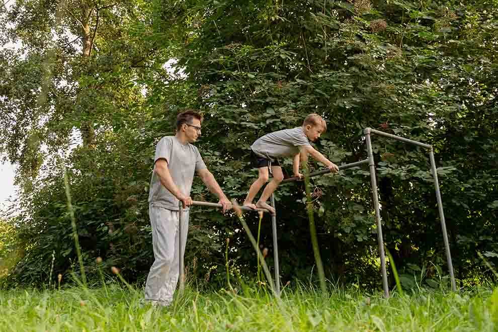 Pai e filho brincando em barras de exercícios ao ar livre